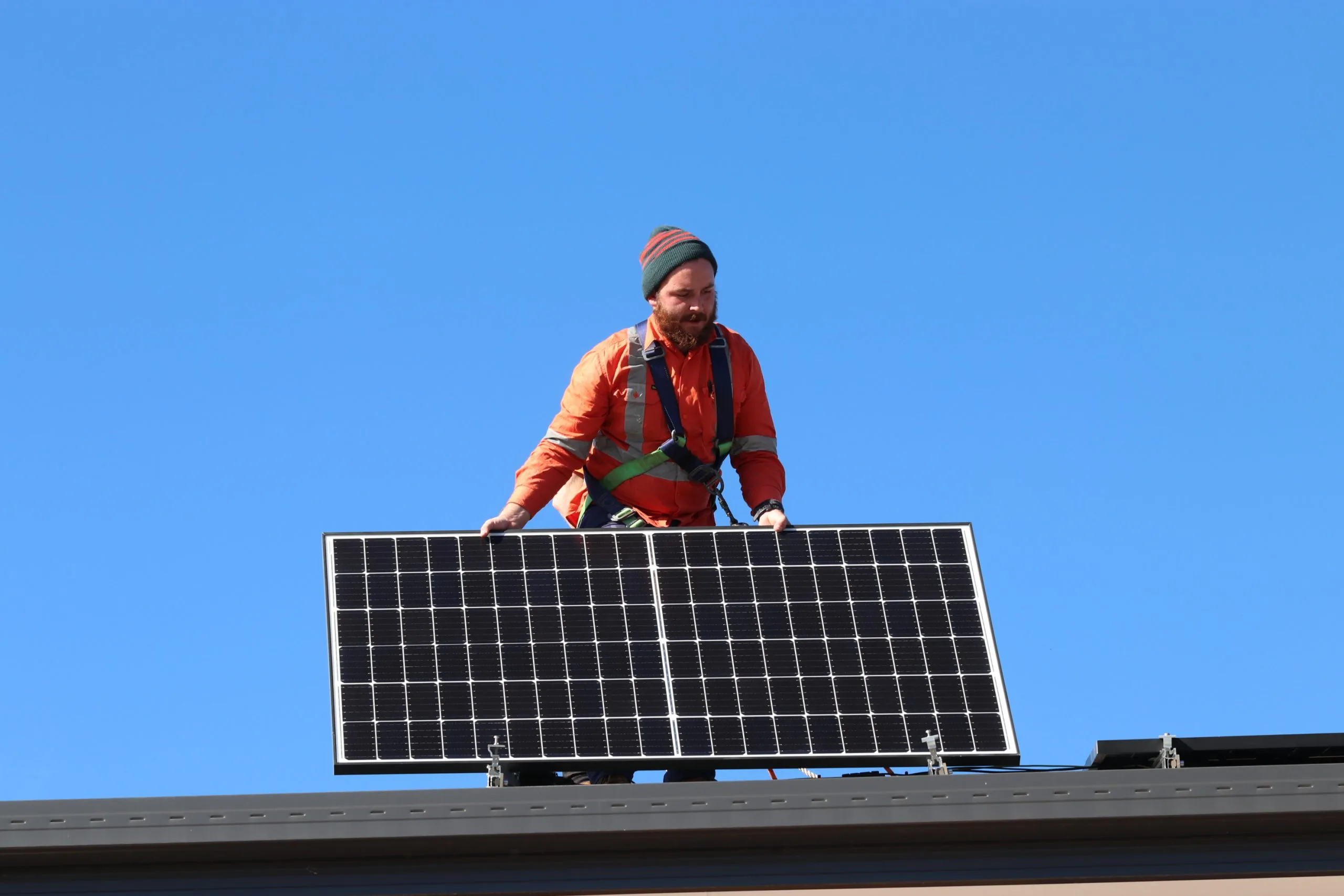 SunBuilt Solar installer holding a solar panel